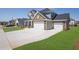 View of house showing driveway, three-car garage, nicely manicured front lawn, and beautifully designed exterior at 307 Ernest Ave, Peachtree City, GA 30269