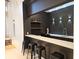 Chic bar area with floating shelves, sink, modern lighting, black cabinetry, and a white countertop at 3777 Peachtree Ne Rd # 1512, Brookhaven, GA 30319