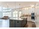 Modern open kitchen with island, stainless appliances, and bright cabinets, open to a living room at 3790 Andover St, Cumming, GA 30028