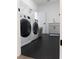 Laundry room with modern washer and dryer, dark flooring, and wire shelving for organized storage at 3790 Andover St, Cumming, GA 30028
