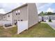 Rear view of townhomes featuring lawn and a white privacy fence at 406 Crescent Woode Dr, Dallas, GA 30157