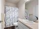 Clean bathroom with a white vanity, toilet, and shower with a floral curtain at 406 Crescent Woode Dr, Dallas, GA 30157