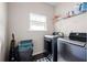 Laundry room with modern washer, dryer, and storage shelves at 406 Crescent Woode Dr, Dallas, GA 30157