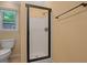 Bathroom featuring a glass-enclosed shower, toilet, and window with backyard view at 5755 Hendrix Rd, Cumming, GA 30040