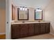 Bathroom vanity area with granite countertops, dual sinks, and wood cabinets at 5755 Hendrix Rd, Cumming, GA 30040