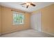 Bedroom featuring neutral carpet, double closet and window overlooking lush backyard at 5755 Hendrix Rd, Cumming, GA 30040