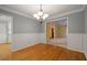 Elegant dining room with hardwood floors, wainscoting, and a view into the living room at 5755 Hendrix Rd, Cumming, GA 30040