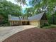 Charming home boasts a well-manicured lawn, and a two-car garage in a lush, wooded setting at 5755 Hendrix Rd, Cumming, GA 30040