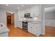 Bright kitchen with white cabinets, stainless steel appliances, and hardwood flooring at 5755 Hendrix Rd, Cumming, GA 30040