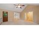 Carpeted living room with a wooden door, views into other rooms, and ample lighting at 5755 Hendrix Rd, Cumming, GA 30040