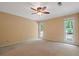 Bright main bedroom with neutral color palette, two large windows and ceiling fan at 5755 Hendrix Rd, Cumming, GA 30040