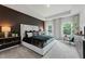 Luxurious main bedroom with a dark accent wall, tray ceiling, and large windows offering natural light at 732 Hedwig Dr, Mcdonough, GA 30252