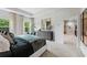Bright main bedroom featuring neutral decor, tray ceiling, a decorative mirror, and ensuite access at 732 Hedwig Dr, Mcdonough, GA 30252
