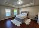 Elegant bedroom with tray ceiling, plush bed, and large windows overlooking the neighborhood at 10650 Allon Cv # 137, Alpharetta, GA 30022