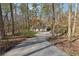 Long driveway leading to a cozy home surrounded by lush trees and a well-kept front lawn at 3510 Riviera Dr, Cumming, GA 30041
