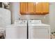 Functional laundry room equipped with modern washer and dryer units and storage cabinets at 3510 Riviera Dr, Cumming, GA 30041