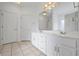 Bright bathroom featuring a double sink vanity with white cabinets and neutral countertops, and a large mirror at 4368 Magnolia Bay Ln, Snellville, GA 30039