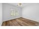 Bright bedroom features wood-look floors, a ceiling fan, and natural light from a window with shutter blinds at 4368 Magnolia Bay Ln, Snellville, GA 30039