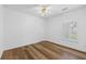 This bedroom offers neutral walls, wood-look floors, natural light, and a ceiling fan with lighting at 4368 Magnolia Bay Ln, Snellville, GA 30039