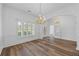 Elegant dining room with hardwood floors, wainscoting, a window, and an elegant chandelier at 4368 Magnolia Bay Ln, Snellville, GA 30039