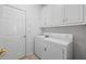 Bright laundry room with storage cabinets and modern washer and dryer at 4368 Magnolia Bay Ln, Snellville, GA 30039