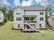 View of the home's backyard featuring a covered patio, stairs to yard, and lush green landscaping at 5075 Briarstone Ridge Way, Alpharetta, GA 30022