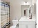 Well-lit bathroom featuring a shower with colorful curtain, a modern vanity, and ample storage space at 5075 Briarstone Ridge Way, Alpharetta, GA 30022