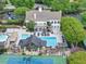 Aerial view of a community clubhouse with a swimming pool, fire pit, lounge chairs and a tennis court at 5075 Briarstone Ridge Way, Alpharetta, GA 30022