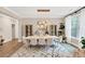 Elegant dining room boasts a large table, modern chandelier, and bright window views at 5075 Briarstone Ridge Way, Alpharetta, GA 30022