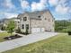 An angled view of a brick home and driveway leading to a two car garage, with a pond in background at 5075 Briarstone Ridge Way, Alpharetta, GA 30022