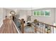 Spacious foyer with wooden and metal staircase and a view of the living room below at 5075 Briarstone Ridge Way, Alpharetta, GA 30022