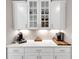 Kitchen with white cabinetry, quartz countertops, and coffee bar area with under-cabinet lighting at 5075 Briarstone Ridge Way, Alpharetta, GA 30022