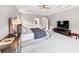 Well-lit main bedroom showcasing a tray ceiling, TV, and neutral color palette at 5075 Briarstone Ridge Way, Alpharetta, GA 30022