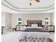 Bright main bedroom with a tray ceiling, carpet and a tufted headboard at 5075 Briarstone Ridge Way, Alpharetta, GA 30022