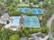 Aerial view of tennis courts surrounded by lush trees, near pool and clubhouse at 5075 Briarstone Ridge Way, Alpharetta, GA 30022