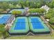 A series of tennis courts in a community, featuring well-maintained green surfaces and professional lighting at 5075 Briarstone Ridge Way, Alpharetta, GA 30022