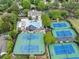 An aerial view showcases multiple tennis courts alongside a community pool, surrounded by lush trees at 5075 Briarstone Ridge Way, Alpharetta, GA 30022