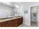 Bathroom featuring a double vanity, wood cabinets, a large mirror, and access to linen storage at 2109 Rugby Ave, Atlanta, GA 30337