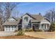 Charming home featuring a gabled roof, inviting front porch with rocking chairs, and a manicured lawn at 2109 Rugby Ave, Atlanta, GA 30337
