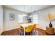 Charming dining room with modern lighting, bright yellow chairs, and hardwood flooring at 2413 Hunting Valley Dr, Decatur, GA 30033