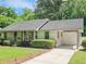 Charming single-story home with well-manicured lawn, mature shrubs, and covered parking at 2413 Hunting Valley Dr, Decatur, GA 30033
