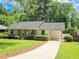 Charming single-story home with well-manicured lawn, mature shrubs, and covered parking at 2413 Hunting Valley Dr, Decatur, GA 30033