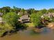 Aerial view showcases the property's serene lakefront setting, mature trees, and well-maintained lawn at 6185 Deerwoods Trl, Alpharetta, GA 30005