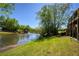 Picturesque backyard with a tranquil lake featuring a fountain, enhanced by a lush lawn and mature trees at 6185 Deerwoods Trl, Alpharetta, GA 30005