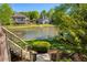 A beautiful backyard with stairs leading down to a tranquil lake surrounded by lush greenery and manicured lawns at 6185 Deerwoods Trl, Alpharetta, GA 30005