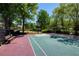 Community basketball court with well-maintained surface, seating, and surrounding trees at 6185 Deerwoods Trl, Alpharetta, GA 30005