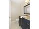 Updated bathroom featuring a dark vanity with brass hardware, tan countertop, and tiled floors at 6185 Deerwoods Trl, Alpharetta, GA 30005