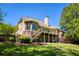 Stately brick home with a spacious deck overlooking a lush backyard and serene lake, perfect for outdoor living at 6185 Deerwoods Trl, Alpharetta, GA 30005