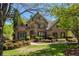 Beautiful brick home featuring manicured lawn, mature trees, and a welcoming entrance at 6185 Deerwoods Trl, Alpharetta, GA 30005
