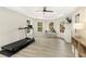 Bright room featuring a treadmill, desk, and TV, perfect for exercise and work at 6185 Deerwoods Trl, Alpharetta, GA 30005